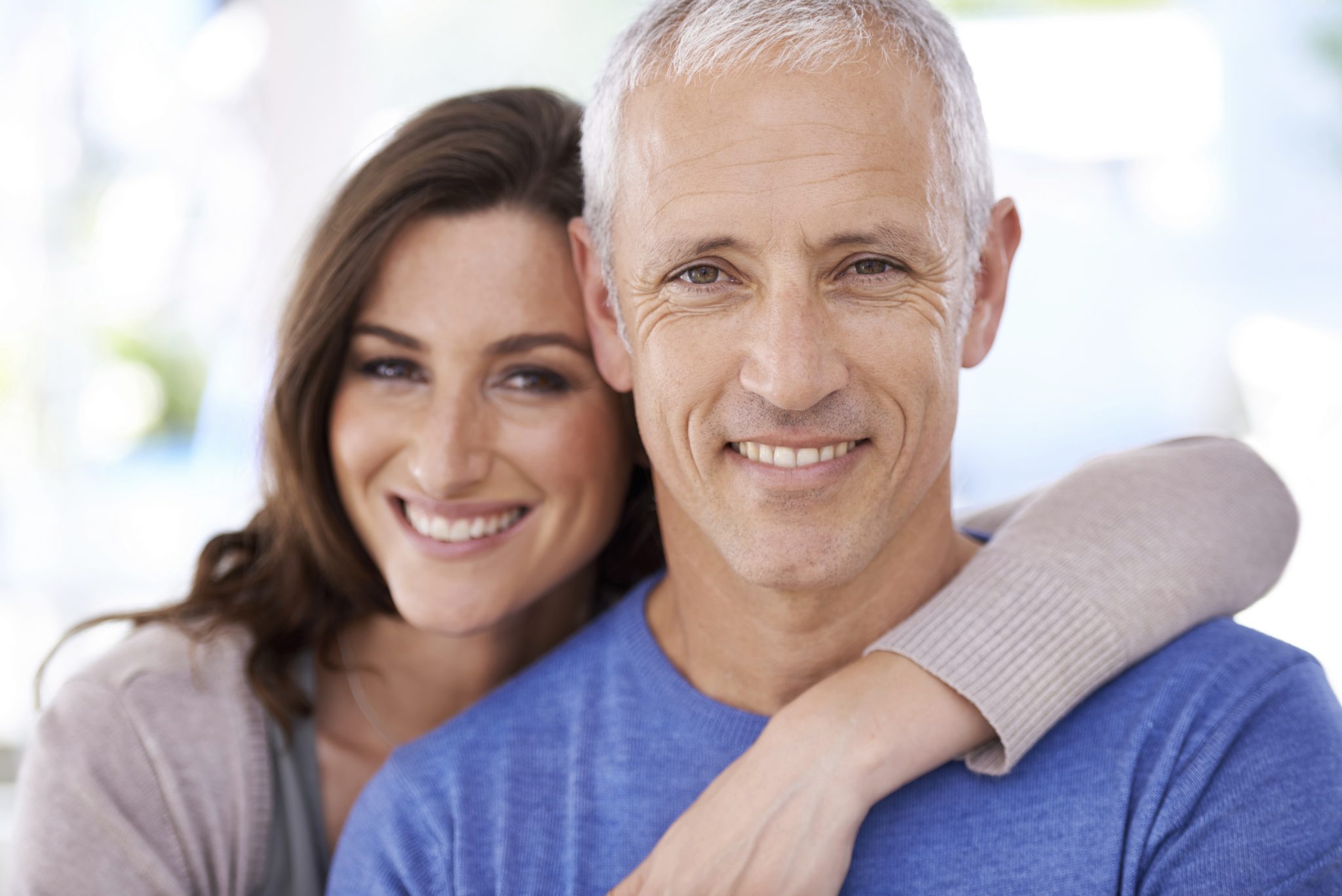 Man and woman with cerec crowns and bridges embracing.
