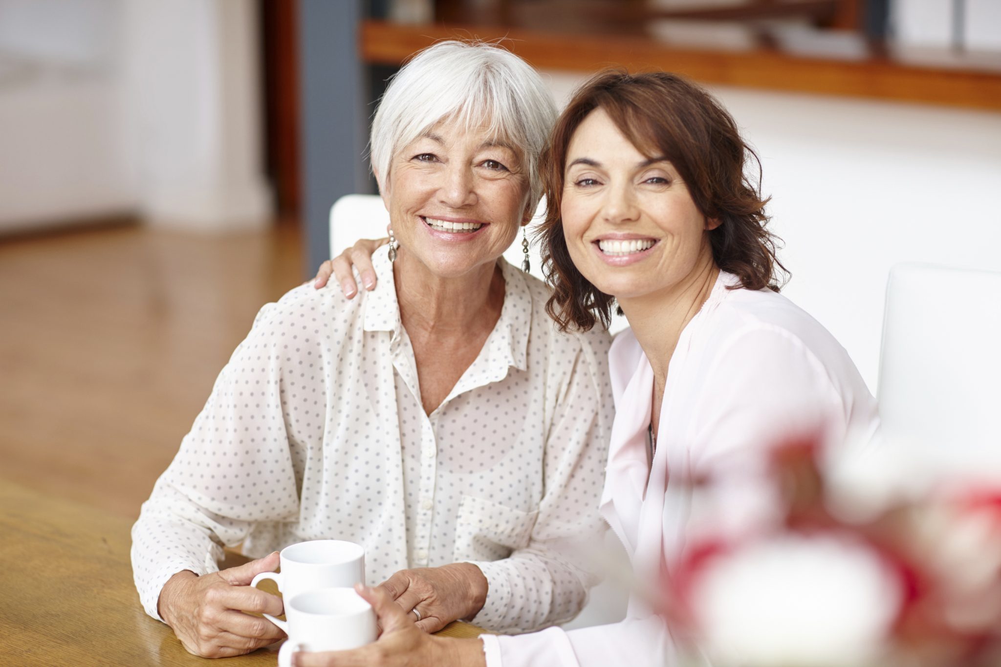 Woman and her mother with dental implants spending time together.