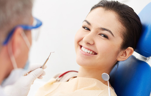 Smiling woman having her teeth examined by a dentist for cosmetic dentistry